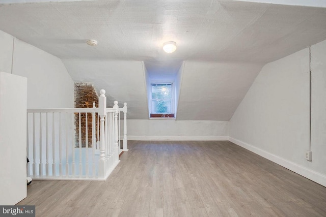 bonus room with lofted ceiling and light hardwood / wood-style flooring