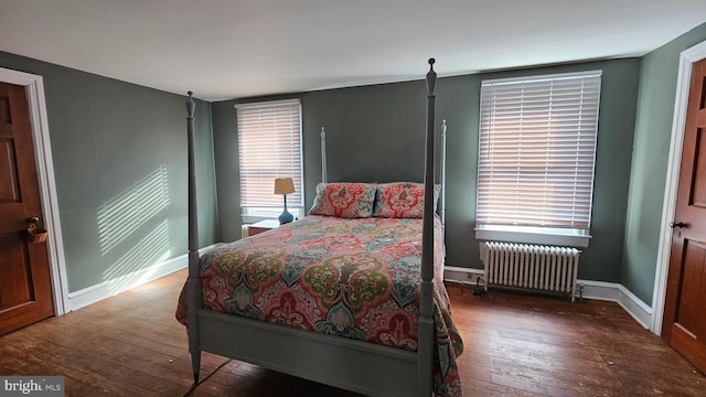 bedroom with dark hardwood / wood-style flooring and radiator heating unit