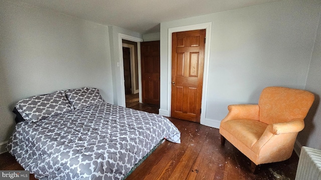 bedroom featuring radiator heating unit and dark wood-type flooring