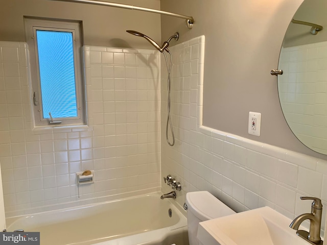 full bathroom featuring sink, tiled shower / bath combo, tile walls, and toilet