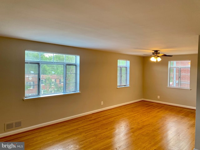 unfurnished room featuring light hardwood / wood-style flooring, ceiling fan, and a healthy amount of sunlight