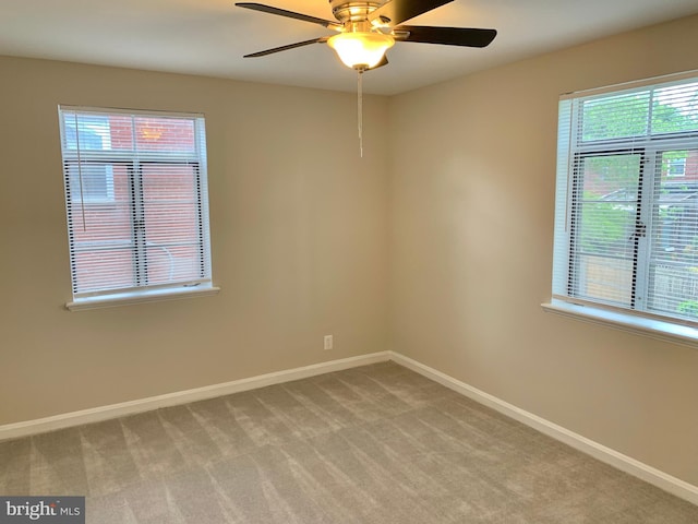 spare room featuring light colored carpet and ceiling fan