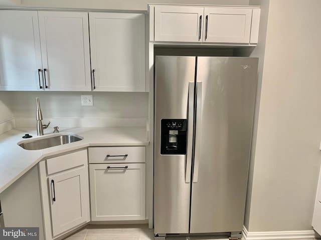 kitchen with white cabinets, sink, and stainless steel refrigerator with ice dispenser