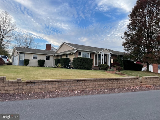 single story home featuring a garage and a front lawn