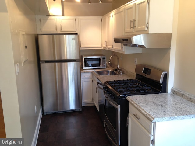 kitchen featuring light stone countertops, appliances with stainless steel finishes, ventilation hood, sink, and white cabinets