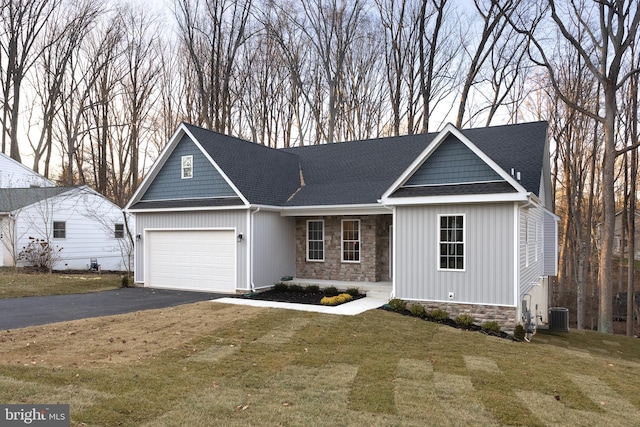 view of front facade featuring central AC, a front lawn, and a garage