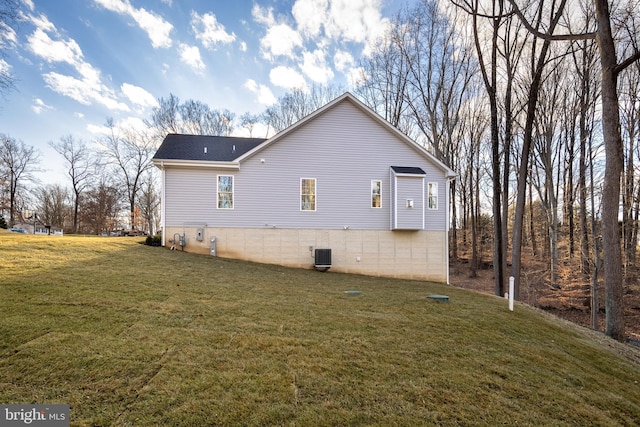 view of side of property with a yard and central air condition unit