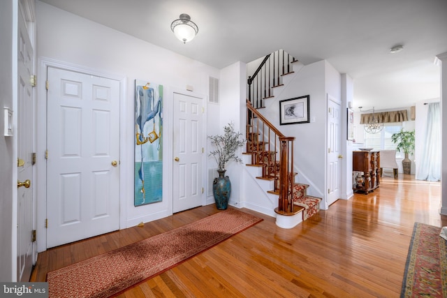 foyer entrance featuring hardwood / wood-style flooring and a chandelier