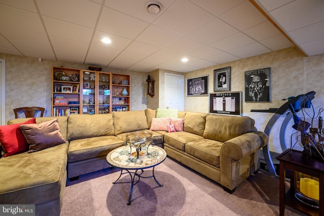 living room featuring carpet and a paneled ceiling