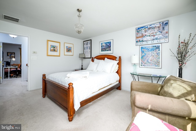 bedroom with a chandelier and light colored carpet