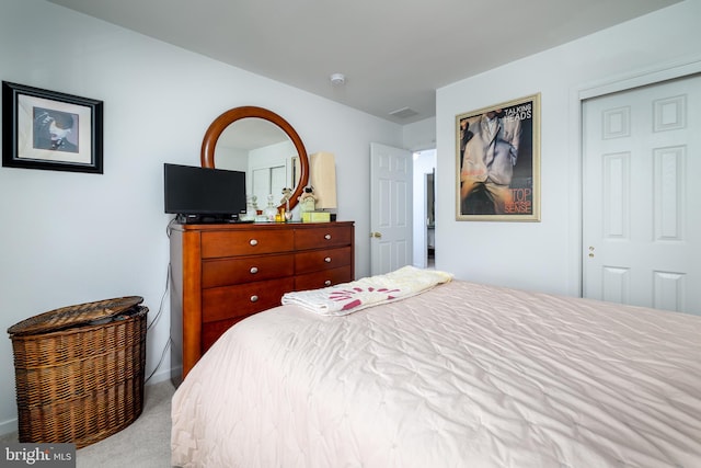 bedroom with light carpet and a closet