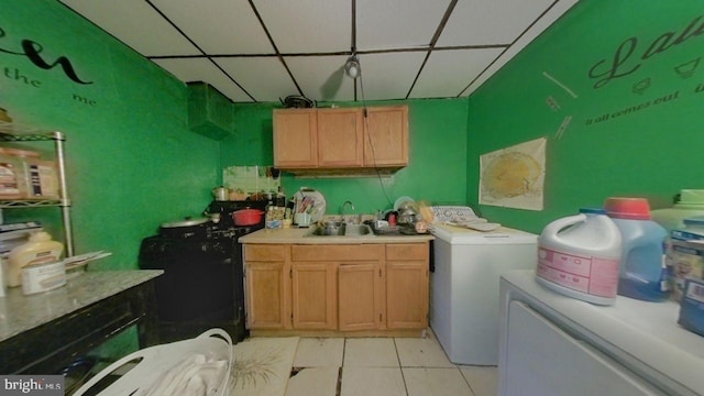 clothes washing area featuring washer / dryer, light tile patterned floors, and sink