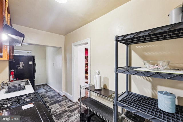 kitchen with black fridge and range hood