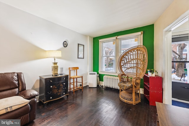 sitting room with dark hardwood / wood-style floors and radiator heating unit