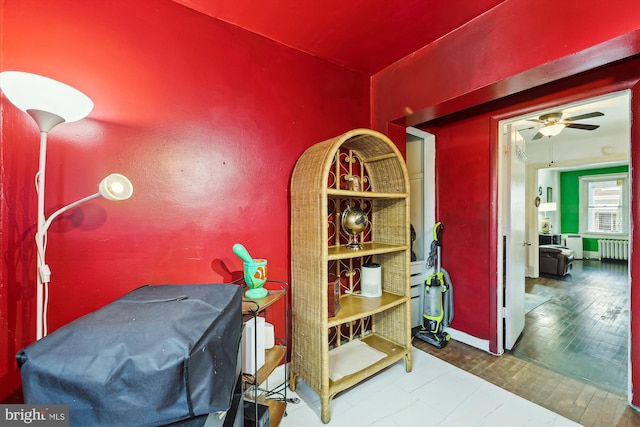 dining area with hardwood / wood-style flooring, radiator heating unit, and ceiling fan