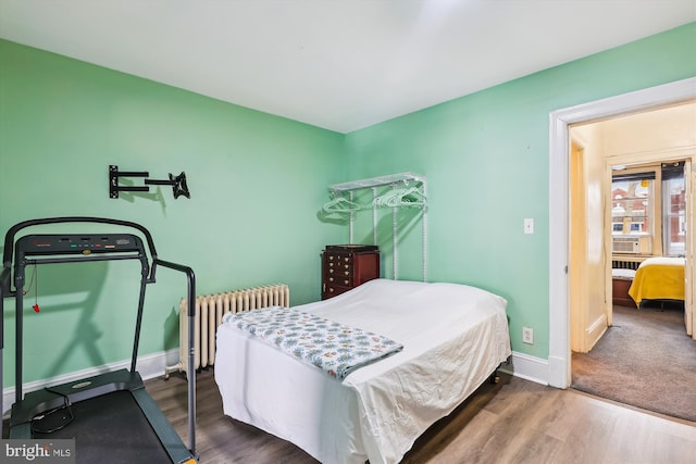 bedroom featuring dark wood-type flooring, radiator, and cooling unit