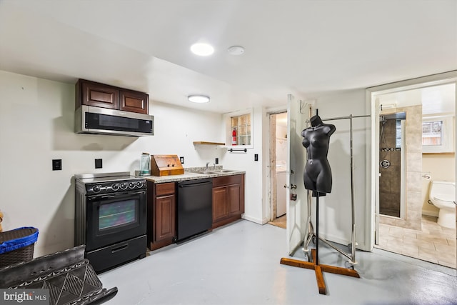 kitchen featuring dark brown cabinetry, sink, and black appliances