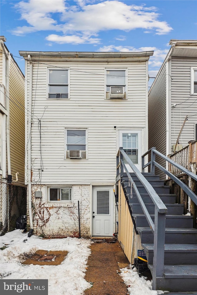 snow covered rear of property with cooling unit