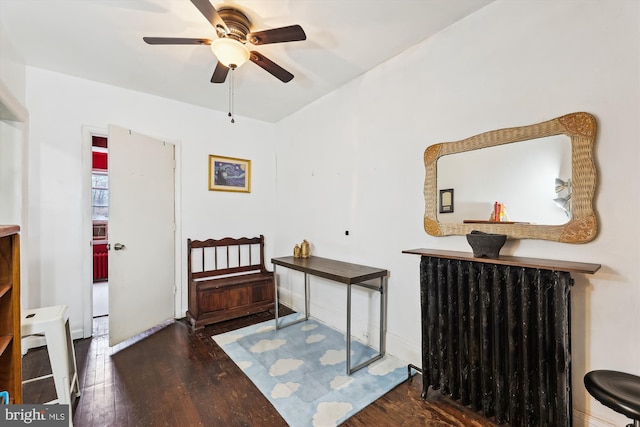 bedroom with dark wood-type flooring, radiator, and ceiling fan