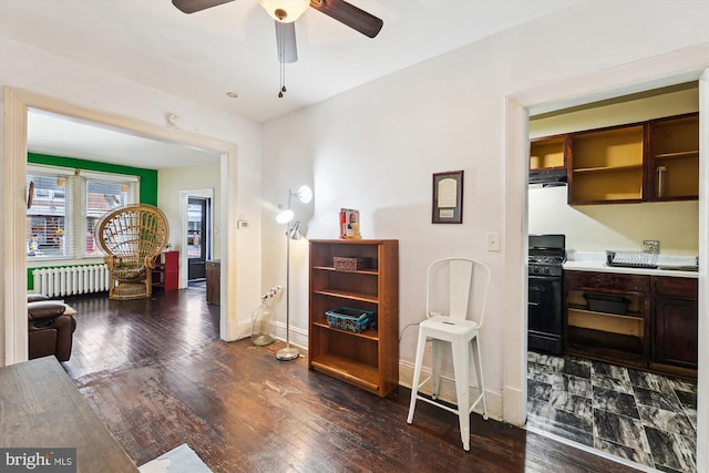 interior space with dark wood-type flooring, radiator heating unit, and ceiling fan