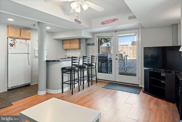 kitchen featuring a ceiling fan, light brown cabinets, wood finished floors, visible vents, and freestanding refrigerator