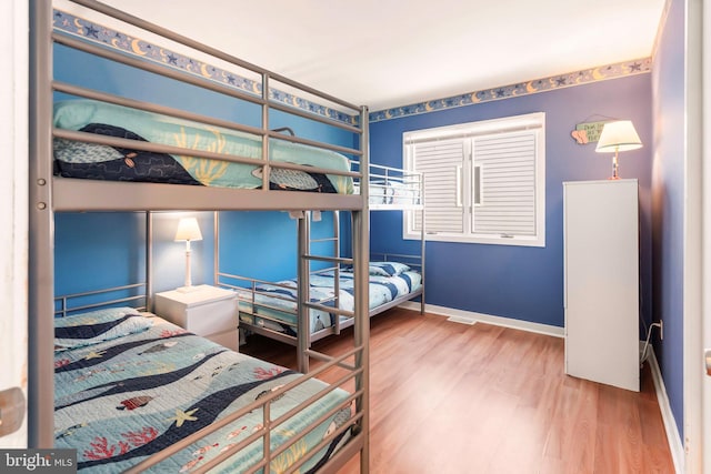 bedroom with baseboards and wood finished floors