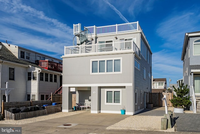 rear view of house with a patio, fence, and driveway