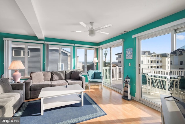 living area with visible vents, wood finished floors, and ceiling fan