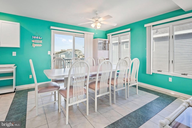 tiled dining room with baseboards and a ceiling fan