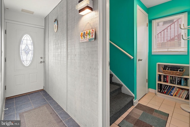 entrance foyer with tile patterned floors, stairway, and baseboards