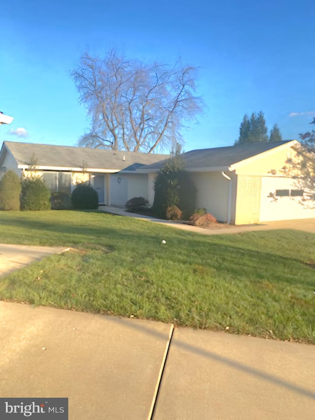 view of front of property with a front yard and a garage