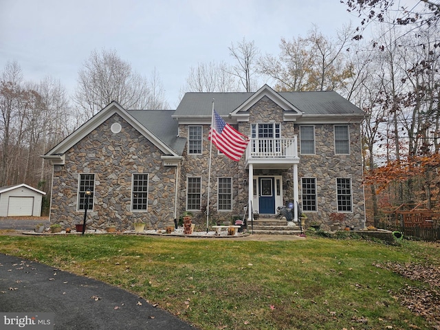 view of front of home featuring a balcony and a front lawn