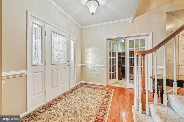 foyer entrance with french doors, light wood-type flooring, and ornamental molding