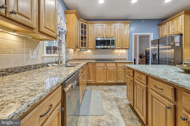 kitchen featuring decorative backsplash, sink, light stone countertops, and stainless steel appliances