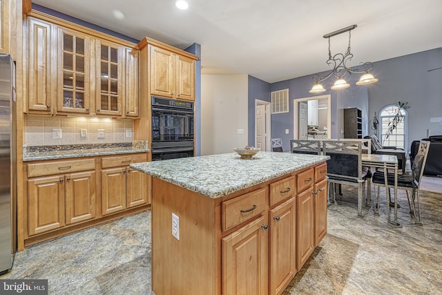 kitchen with a center island, an inviting chandelier, tasteful backsplash, black double oven, and decorative light fixtures