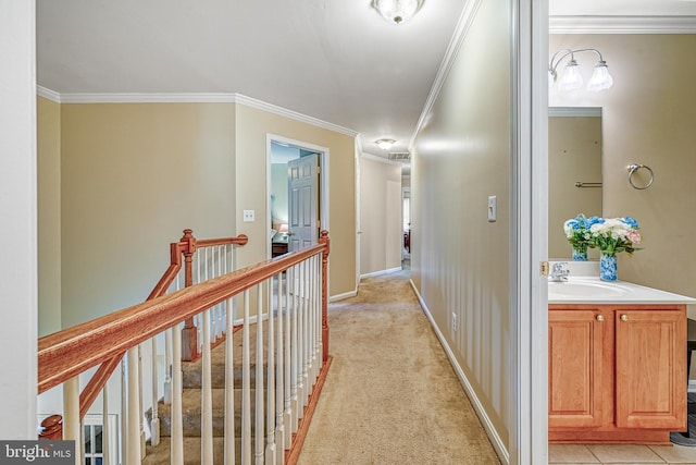 hallway featuring sink, light colored carpet, and ornamental molding