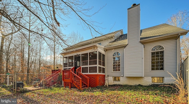 rear view of house featuring a sunroom