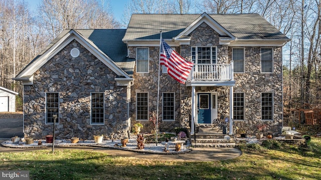 view of front of house featuring a front yard and a balcony