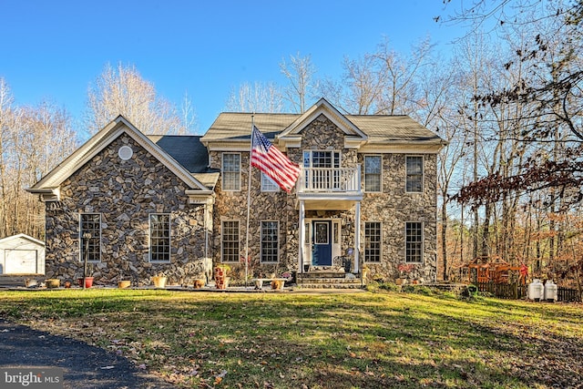 view of front of property with a garage, a balcony, an outdoor structure, and a front yard