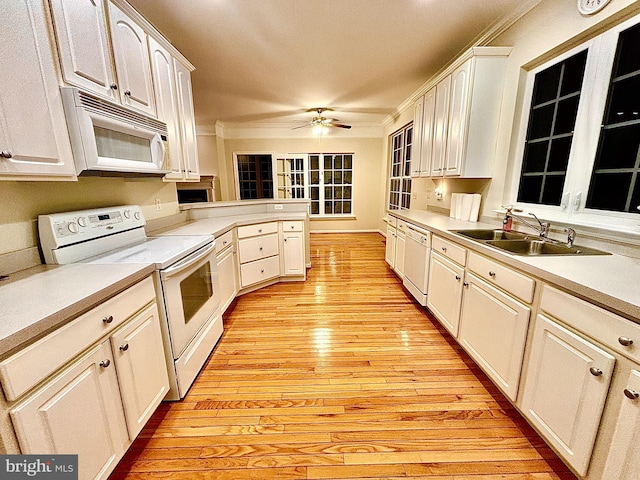 kitchen with white cabinetry, sink, light hardwood / wood-style floors, white appliances, and ornamental molding