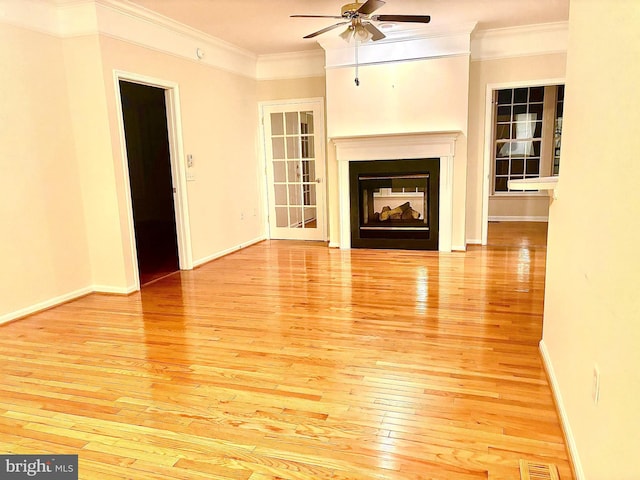 unfurnished living room featuring ceiling fan, light hardwood / wood-style floors, and ornamental molding