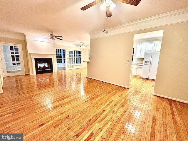 unfurnished living room with light hardwood / wood-style floors, a multi sided fireplace, ornamental molding, and a textured ceiling