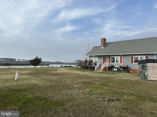 view of yard with a deck with water view