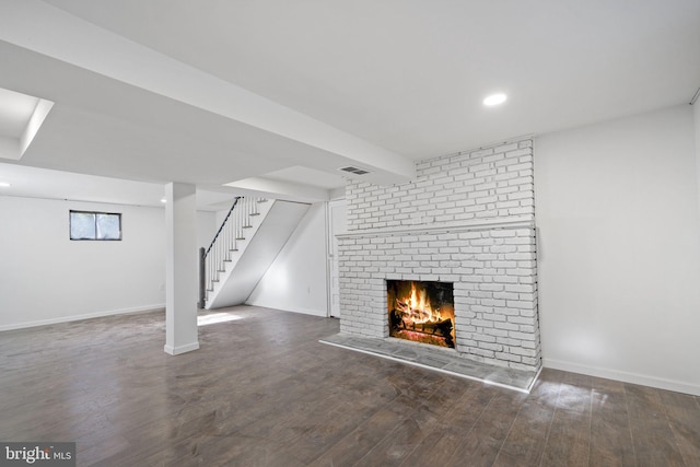 unfurnished living room featuring a fireplace and dark hardwood / wood-style floors