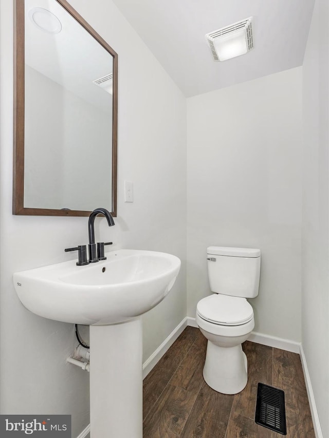 9732 Garis Shop Rd, Hagerstown, MD 21740 - half bathroom with toilet, baseboards, wood finished floors, and a sink