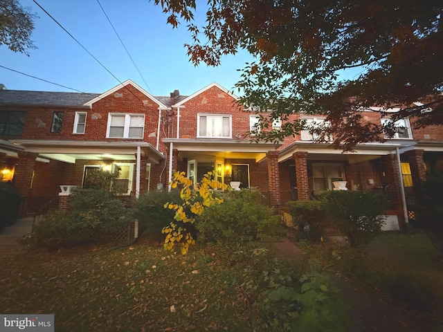 back house at dusk with covered porch