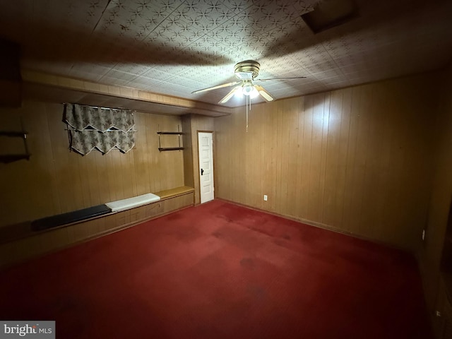 basement featuring carpet flooring and wood walls