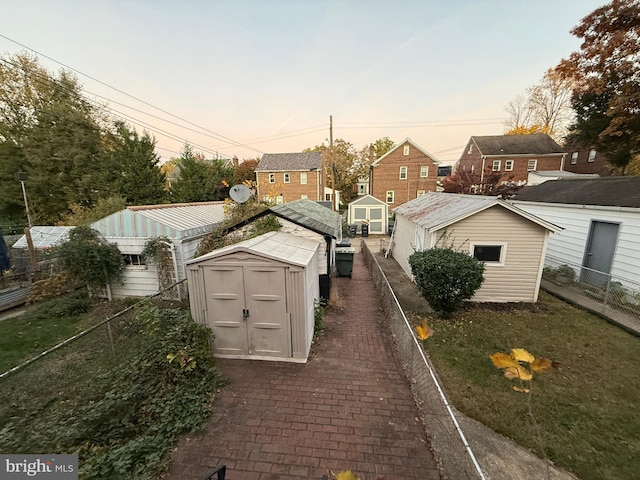 yard at dusk featuring a storage shed