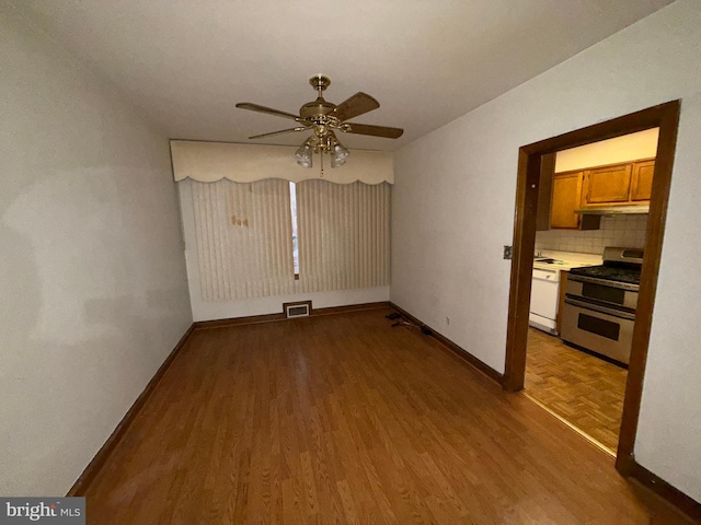 empty room with hardwood / wood-style floors and ceiling fan