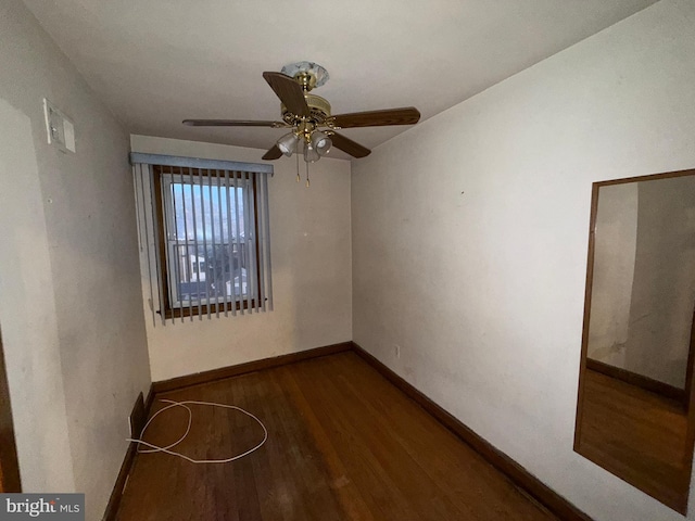 spare room with dark hardwood / wood-style floors and ceiling fan